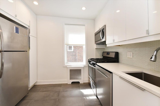 36 Barstow Unit 2-B, Great Neck, NY 11021 - kitchen featuring white cabinets, stainless steel appliances, decorative backsplash, and a sink
