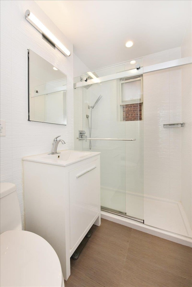 36 Barstow Unit 2-B, Great Neck, NY 11021 - bathroom with a shower stall, toilet, recessed lighting, tile walls, and vanity