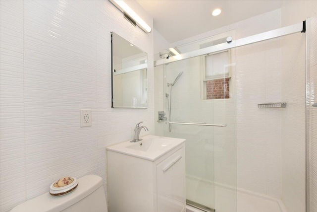 36 Barstow Unit 2-B, Great Neck, NY 11021 - bathroom featuring toilet, a stall shower, tile walls, and vanity