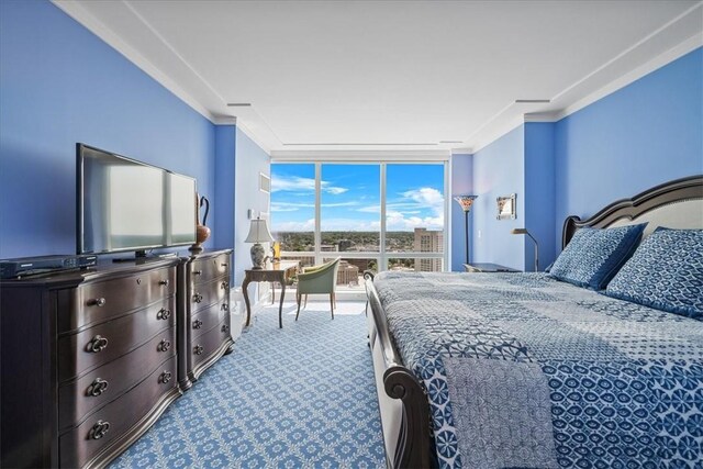 bedroom featuring crown molding, expansive windows, and carpet
