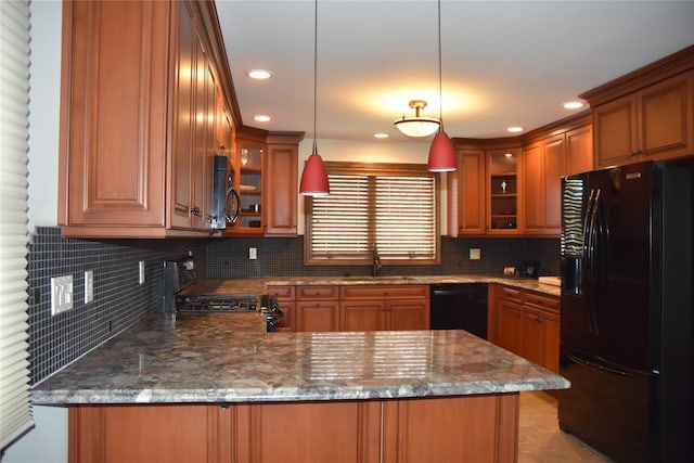 kitchen with a sink, brown cabinets, black appliances, and a peninsula