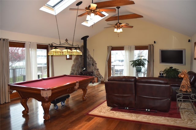 recreation room with a wood stove, a ceiling fan, lofted ceiling with skylight, and wood finished floors