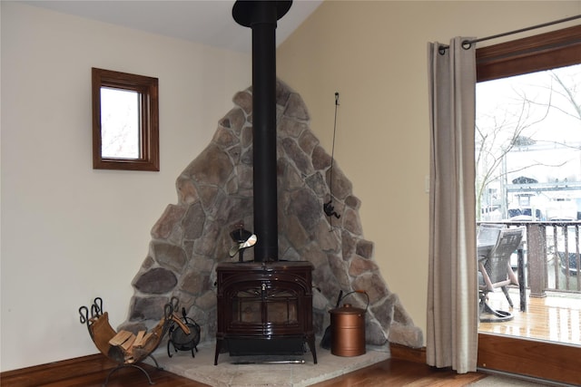 interior details with wood finished floors and a wood stove