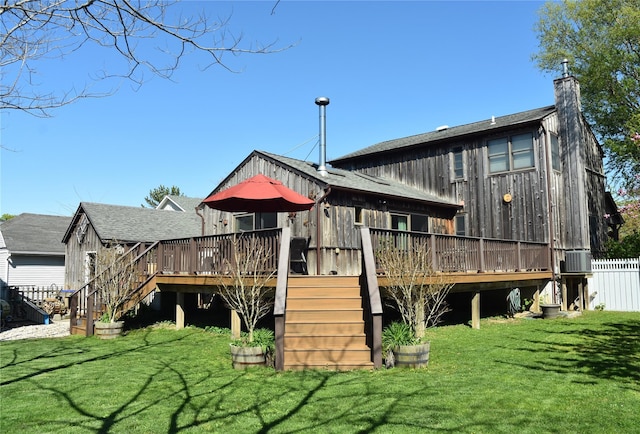 rear view of house featuring stairway, a deck, a yard, and fence