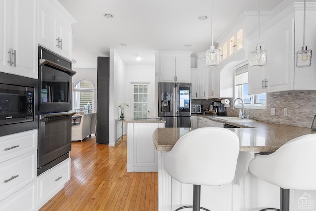 67 Latham Cir, Saugerties, NY 12477 - kitchen with stainless steel fridge, built in microwave, white cabinets, tasteful backsplash, and recessed lighting