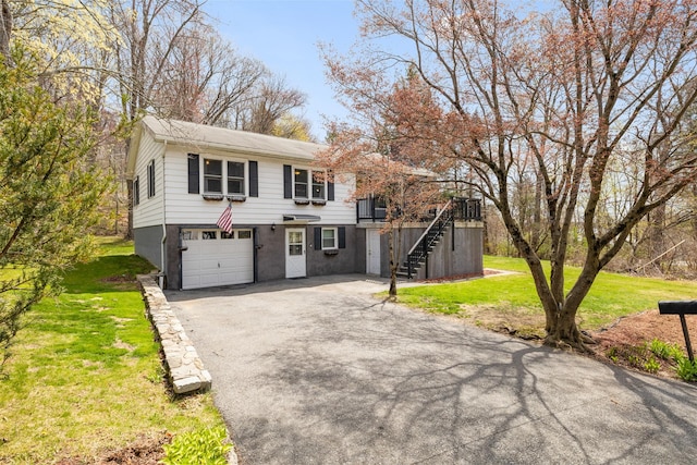 view of front of home with stairway, a front lawn, driveway, and an attached garage