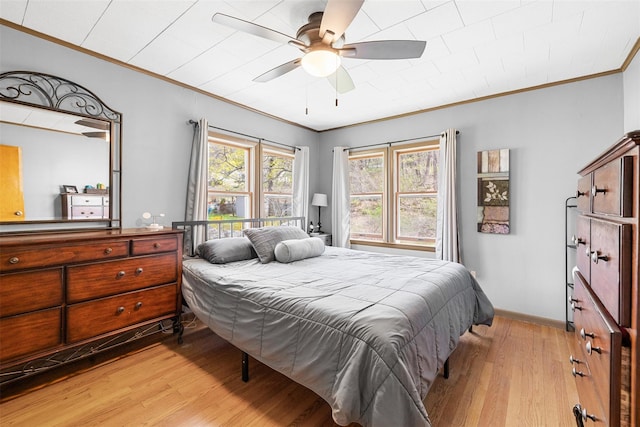 bedroom with light wood-type flooring, a ceiling fan, ornamental molding, and baseboards