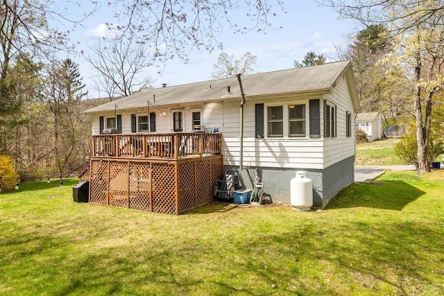 back of property featuring a lawn, a deck, crawl space, and a shingled roof