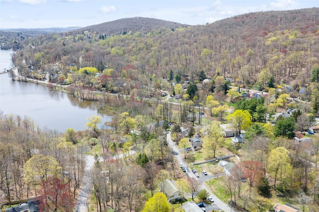 aerial view with a water and mountain view and a view of trees