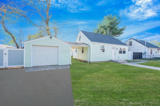 view of front facade with fence, aphalt driveway, a front lawn, and a garage