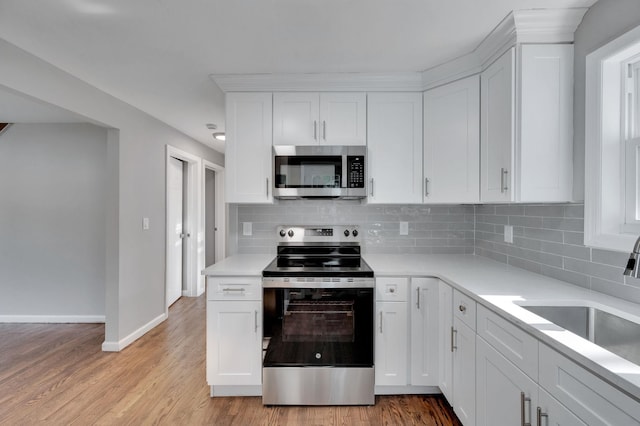 kitchen with a sink, white cabinets, and appliances with stainless steel finishes