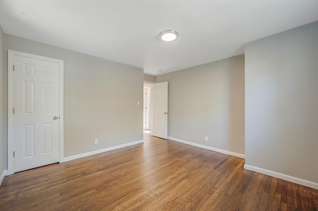 empty room featuring wood finished floors and baseboards