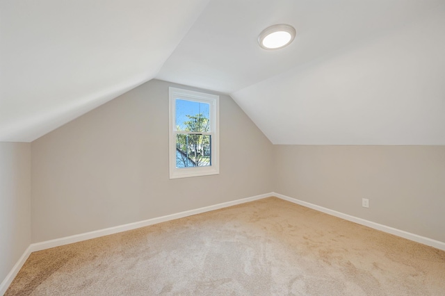 additional living space with vaulted ceiling, carpet floors, and baseboards