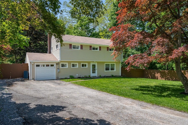 colonial home with a garage and asphalt driveway