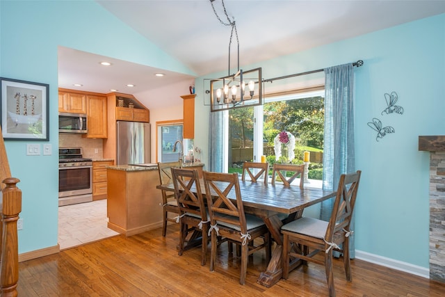 dining area featuring lofted ceiling, wood finished floors, a chandelier, recessed lighting, and baseboards