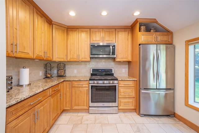 kitchen with stainless steel appliances, light stone countertops, backsplash, recessed lighting, and baseboards