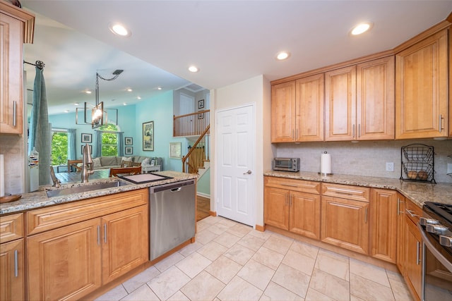 kitchen with appliances with stainless steel finishes, a sink, decorative backsplash, recessed lighting, and light stone countertops
