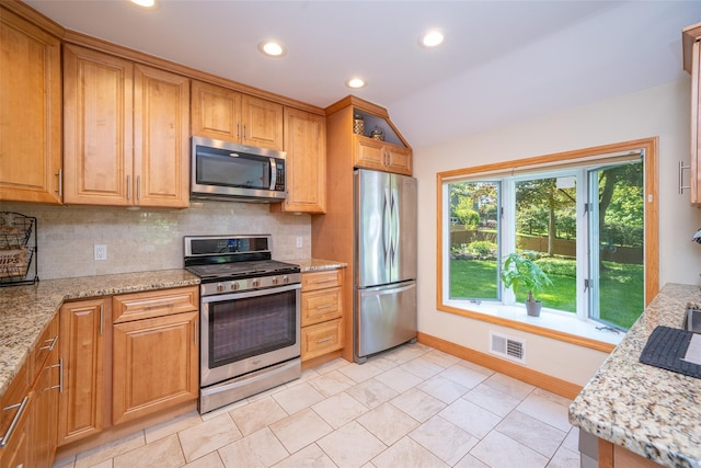 kitchen with appliances with stainless steel finishes, baseboards, backsplash, recessed lighting, and vaulted ceiling