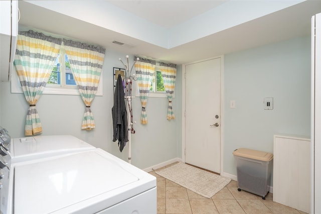 washroom with separate washer and dryer, light tile patterned floors, and baseboards