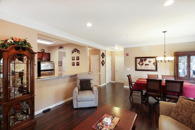 living area with dark wood-type flooring, visible vents, ornamental molding, and a chandelier