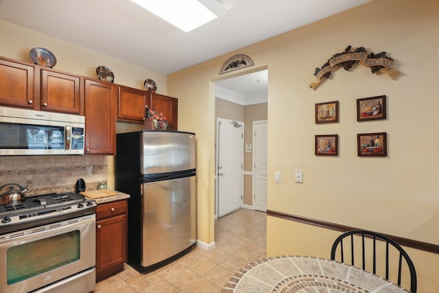 kitchen featuring light tile patterned floors, brown cabinets, tasteful backsplash, appliances with stainless steel finishes, and light countertops