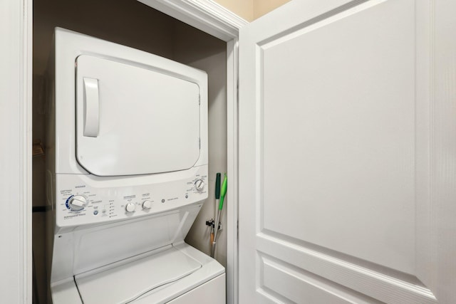 washroom featuring stacked washer / dryer and laundry area