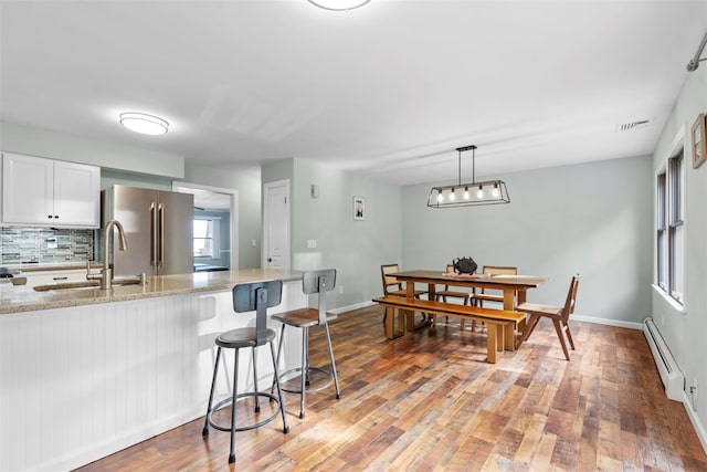 110 Gedney St, Nyack, NY 10960 - kitchen featuring a baseboard radiator, freestanding refrigerator, light stone countertops, and light wood-style flooring