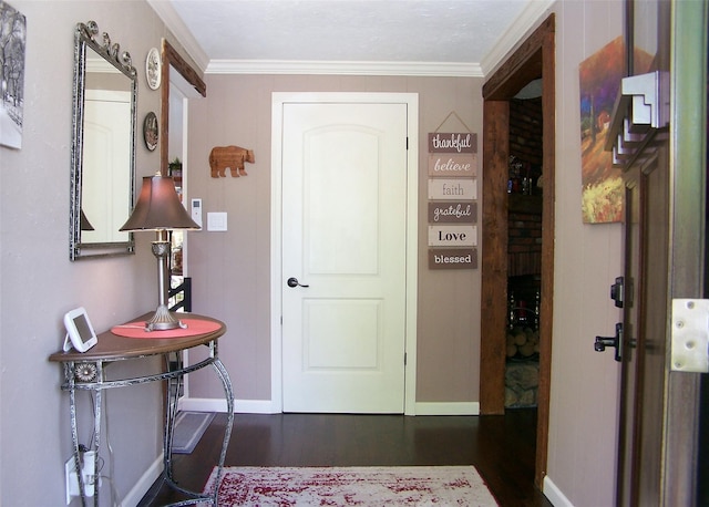 foyer featuring baseboards, dark wood finished floors, and crown molding