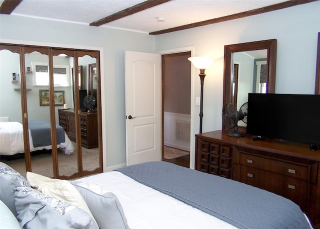 bedroom with a closet, visible vents, beam ceiling, french doors, and carpet flooring