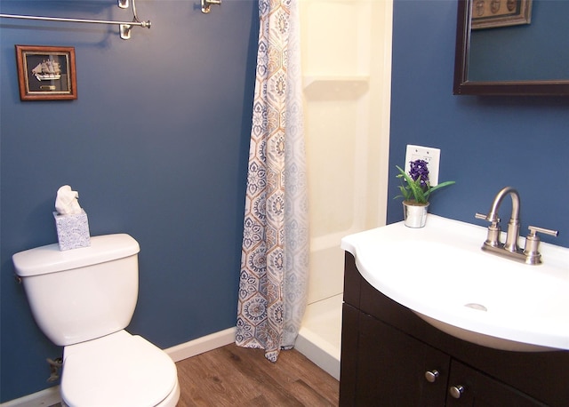 bathroom featuring vanity, toilet, baseboards, wood finished floors, and a shower with curtain