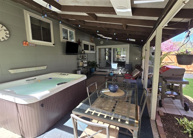 view of patio / terrace with fence, outdoor dining space, and a hot tub