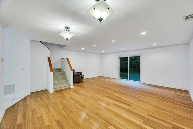 interior space featuring stairway, light wood-style floors, visible vents, baseboards, and recessed lighting
