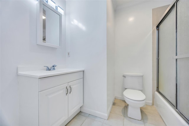 bathroom with vanity, toilet, crown molding, baseboards, and tile patterned flooring