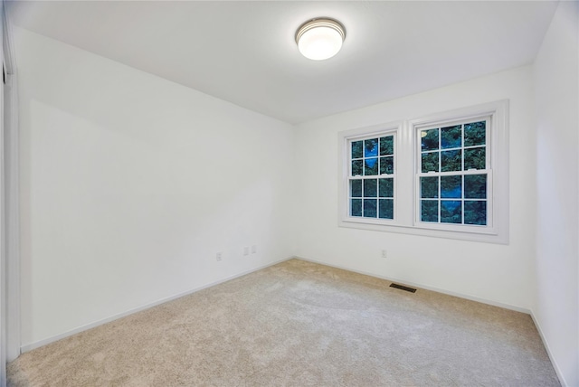 spare room featuring visible vents, carpet floors, and baseboards