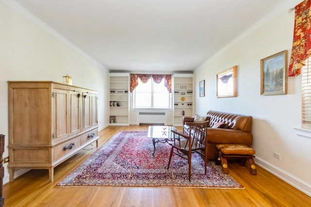 living room with crown molding, radiator, built in features, baseboards, and light wood-type flooring