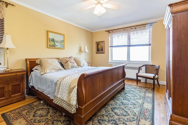 bedroom with a ceiling fan, ornamental molding, radiator, and light wood finished floors