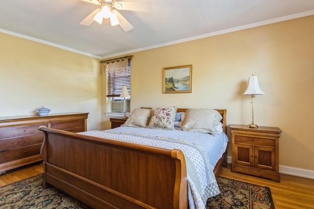 bedroom with crown molding, a ceiling fan, baseboards, and wood finished floors