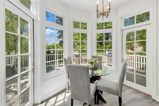 sunroom / solarium featuring a notable chandelier and french doors