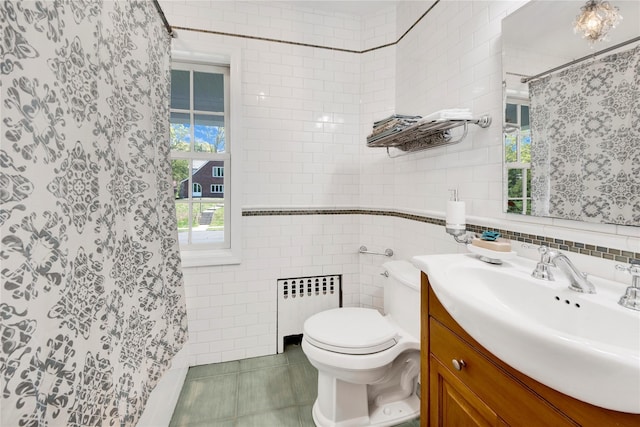 bathroom with vanity, radiator, curtained shower, toilet, and tile walls
