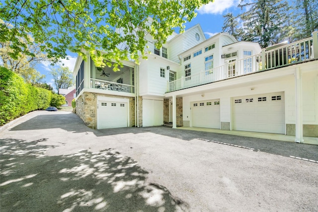 view of front of house with an attached garage, driveway, and stone siding