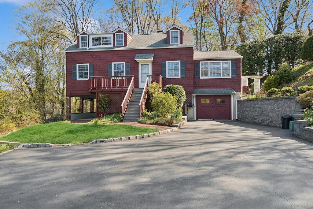 15 Wainscott Ln, East Setauket, NY 11733 - view of front of house featuring driveway, a deck, a shingled roof, an attached garage, and stairway