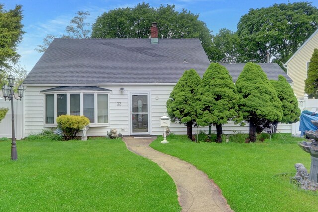 view of front facade featuring a chimney and a shingled roof