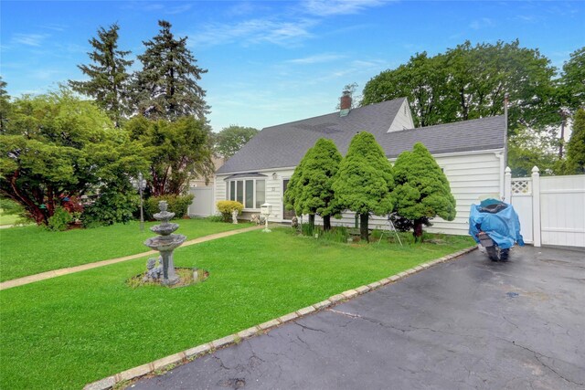view of front of property with roof with shingles, a chimney, and a patio area