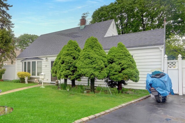 view of side of home featuring roof with shingles and a chimney