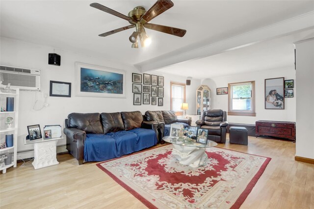 living area with wood finished floors, a ceiling fan, arched walkways, and an AC wall unit
