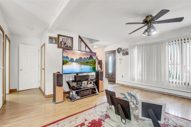 living room featuring a baseboard heating unit, wood finished floors, a ceiling fan, plenty of natural light, and beam ceiling