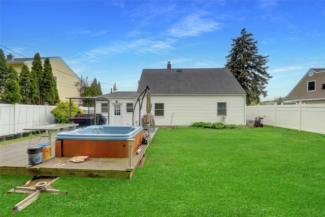 rear view of house with a hot tub, a deck, and a shingled roof