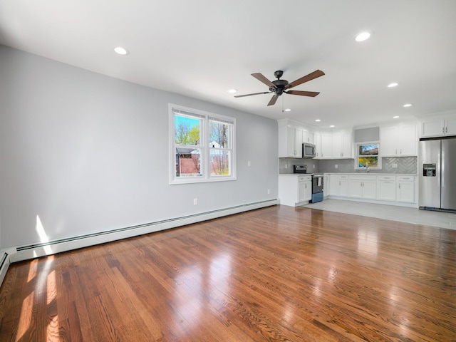 unfurnished living room with recessed lighting, a healthy amount of sunlight, and ceiling fan