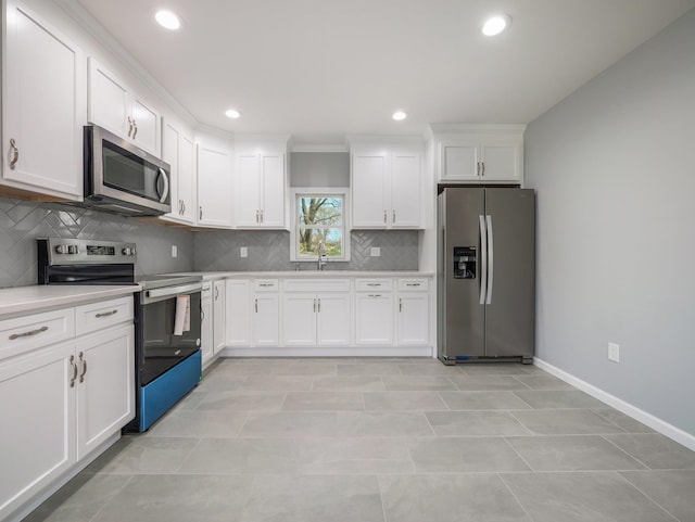 kitchen with a sink, stainless steel appliances, decorative backsplash, white cabinetry, and light countertops