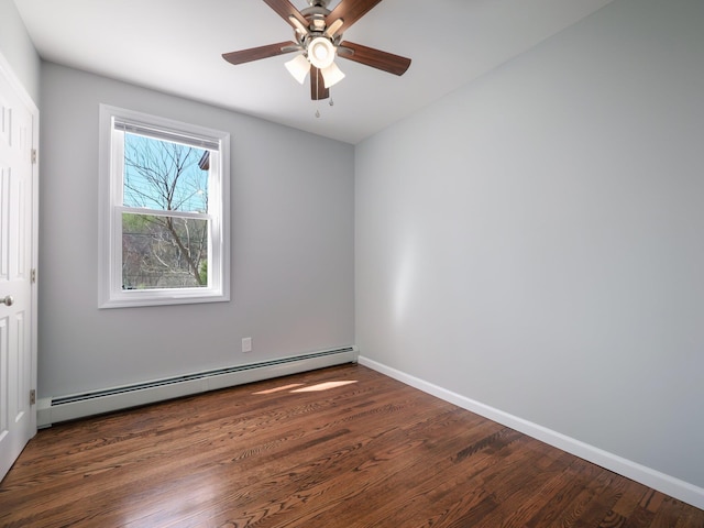 spare room featuring a baseboard radiator, wood finished floors, a ceiling fan, and baseboards